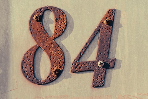Rust on cast iron metal number on wall