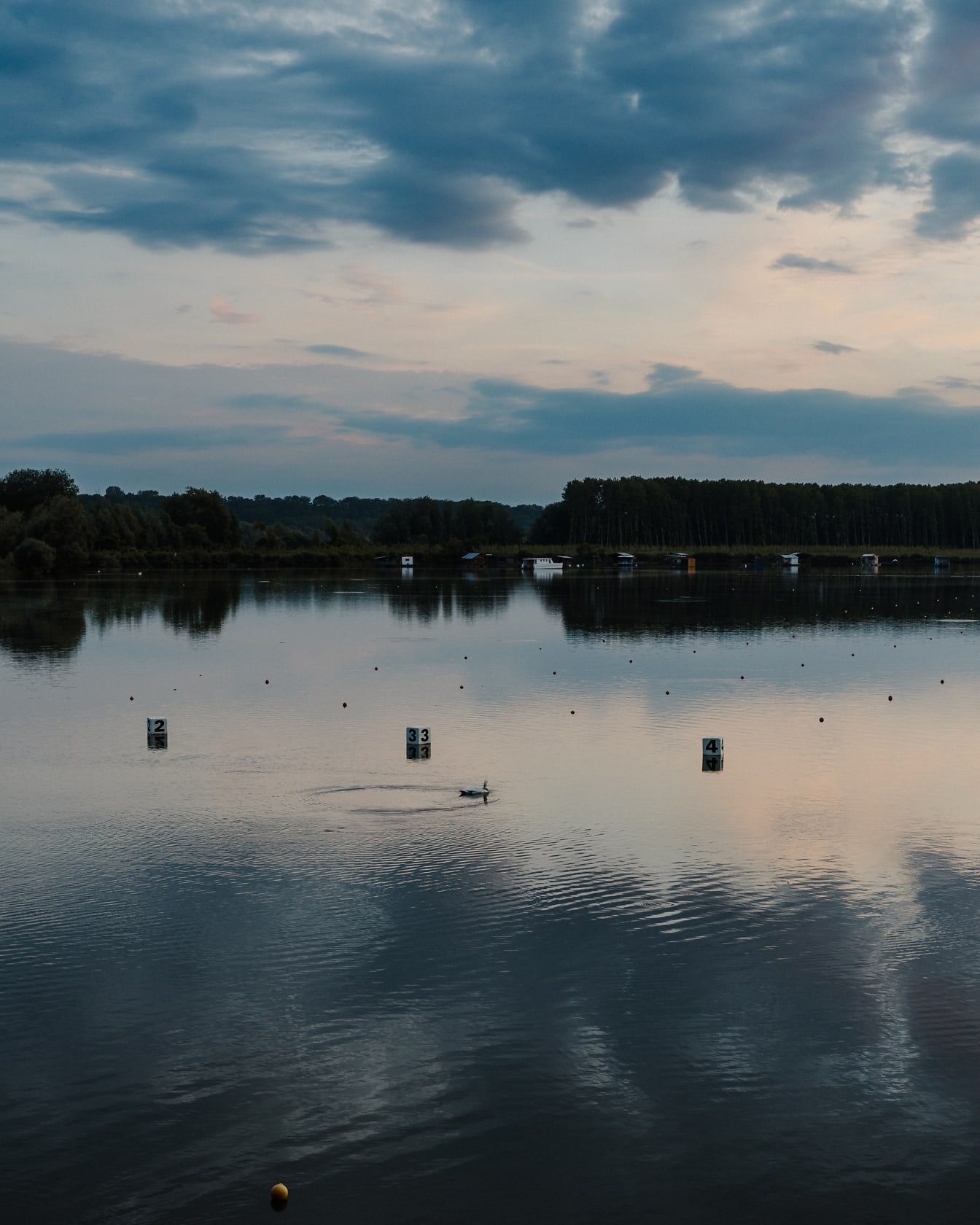 Отражение темно-синих облаков на спокойном озере в сумерках