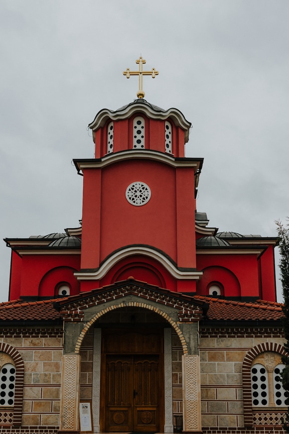 Dark red church tower with gold cross on orthodox church