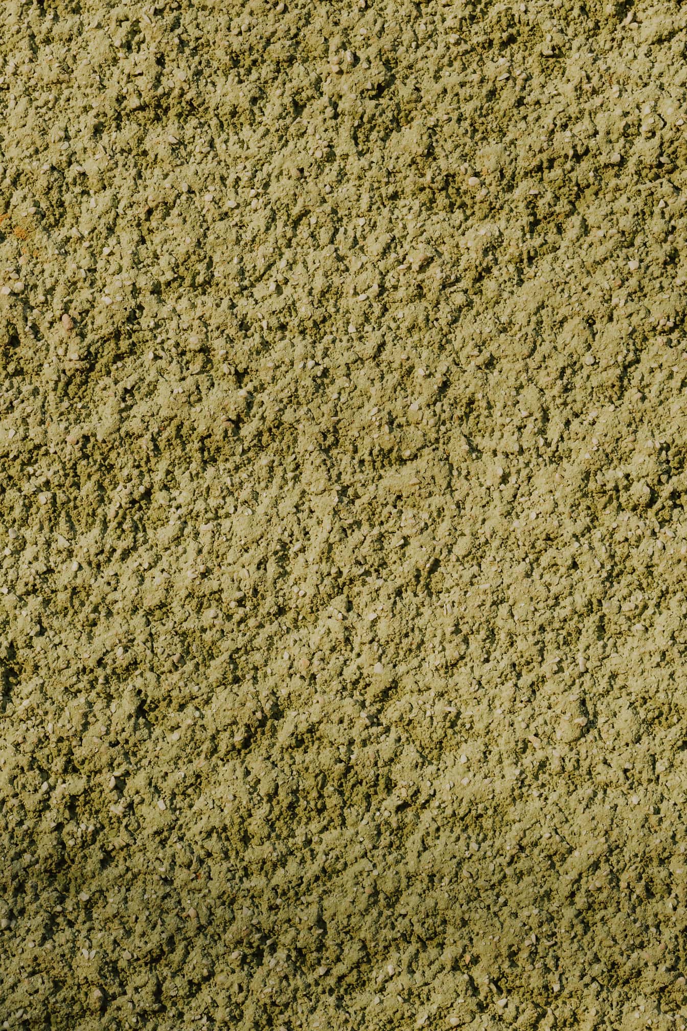 Зеленикаво жълта груба циментова стена текстура близък план
