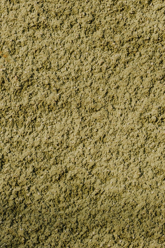 Groenachtig gele ruwe close-up van de cementmuurtextuur