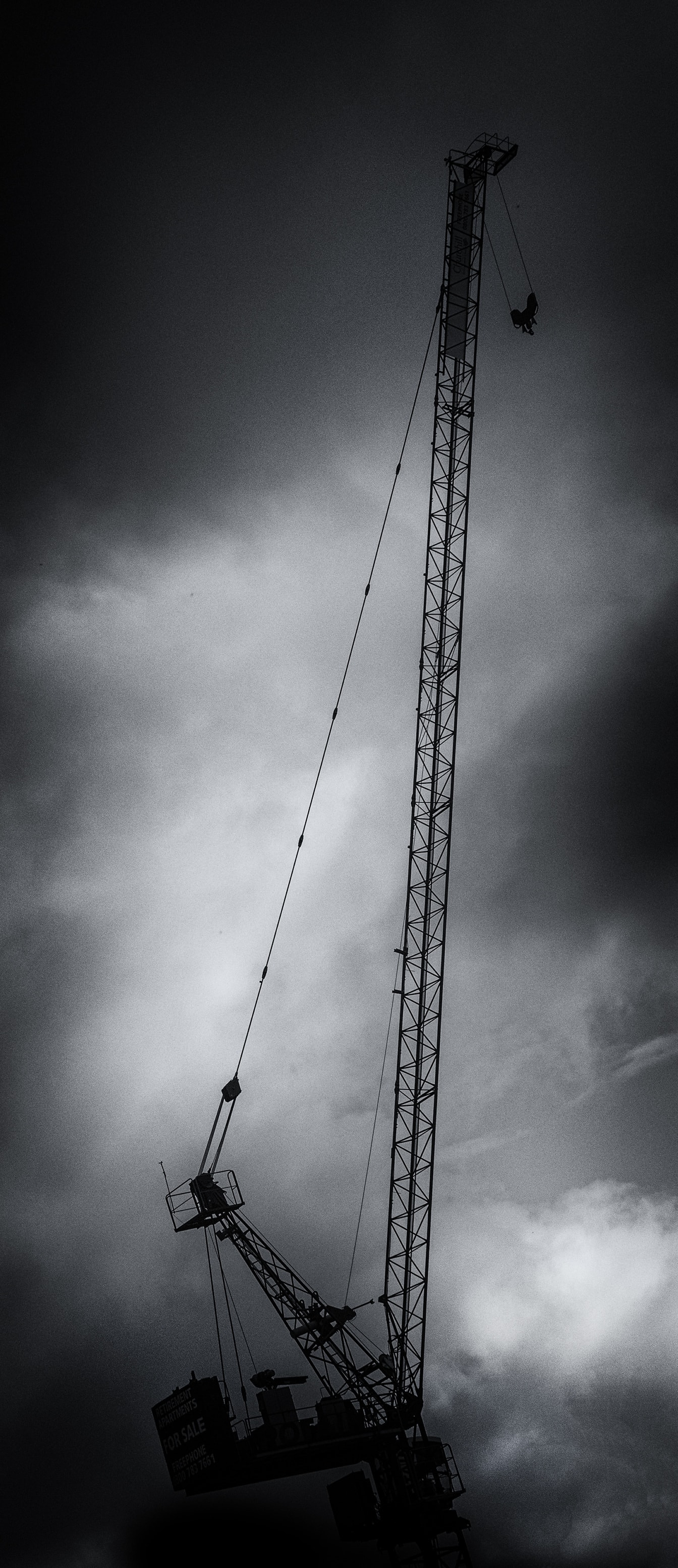Korkea nosturi rakennustyömaalla mustavalkoinen valokuva