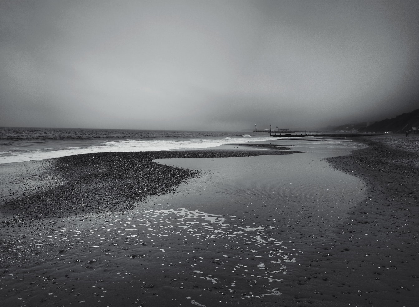 Pláž Bournemouth pri odlive čiernobiela fotografia morskej scenérie