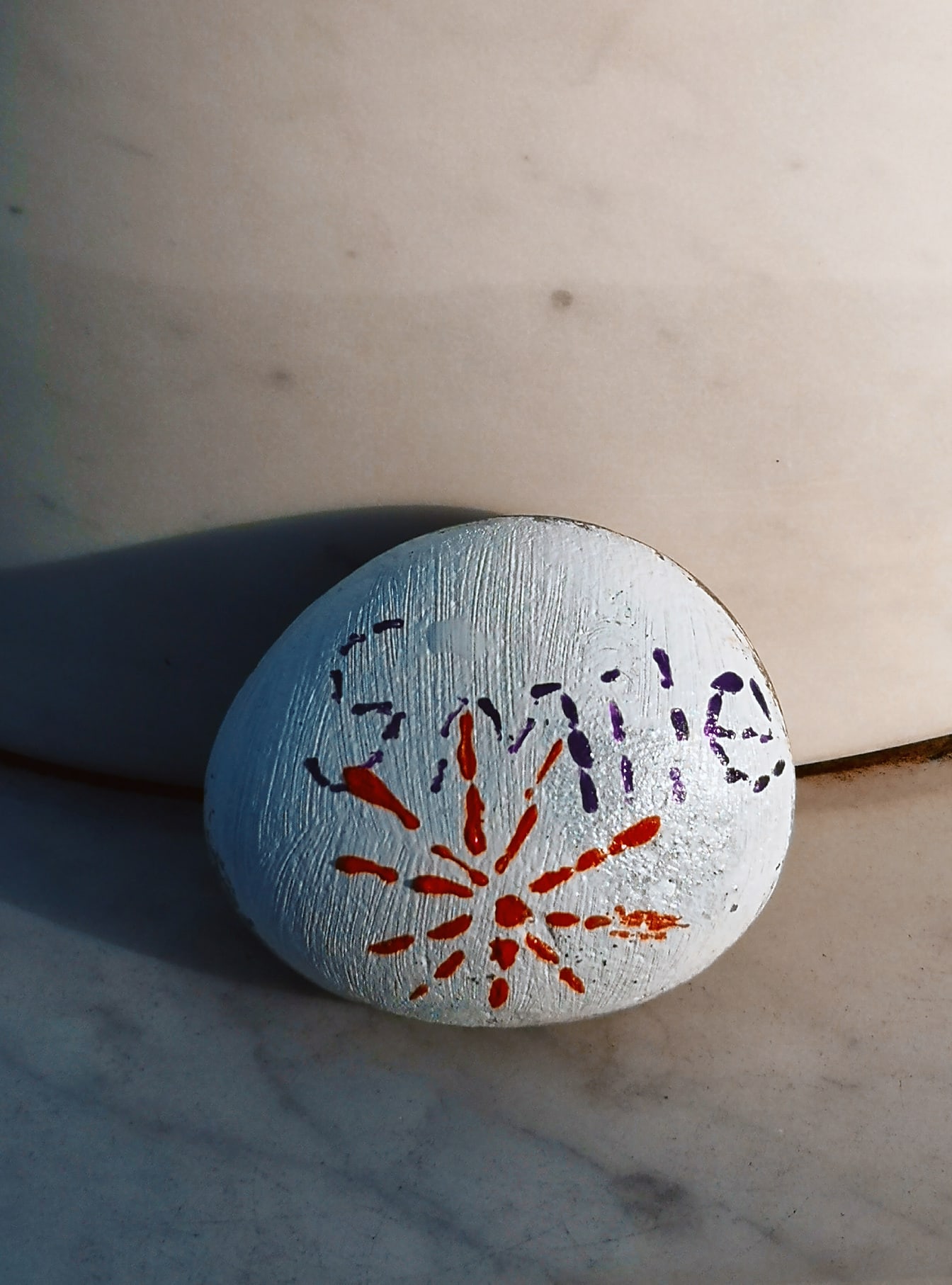 Texto do sorriso na pedra redonda de seixos feita à mão