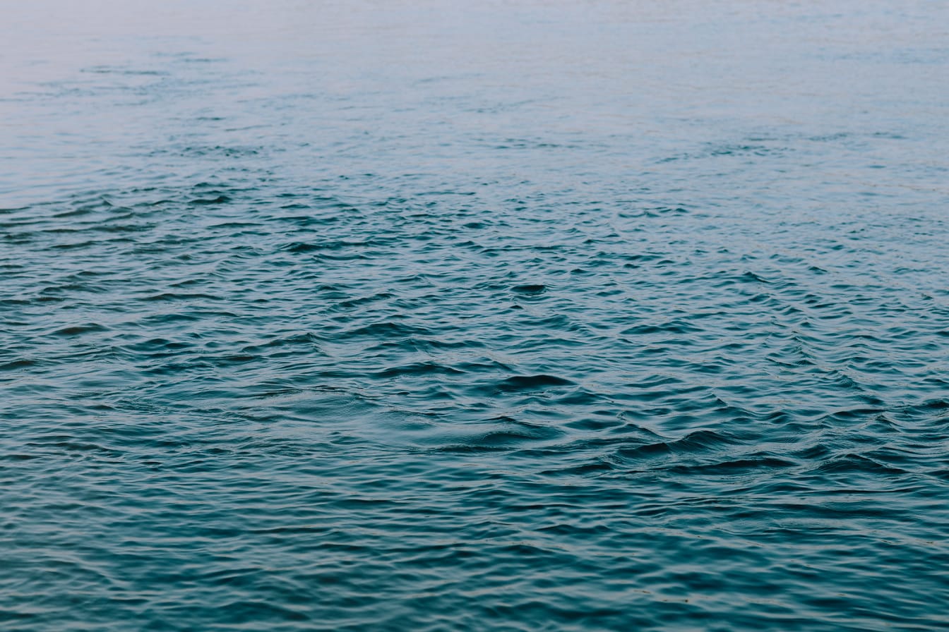 Azure blue waves ripple on calm ocean horizon