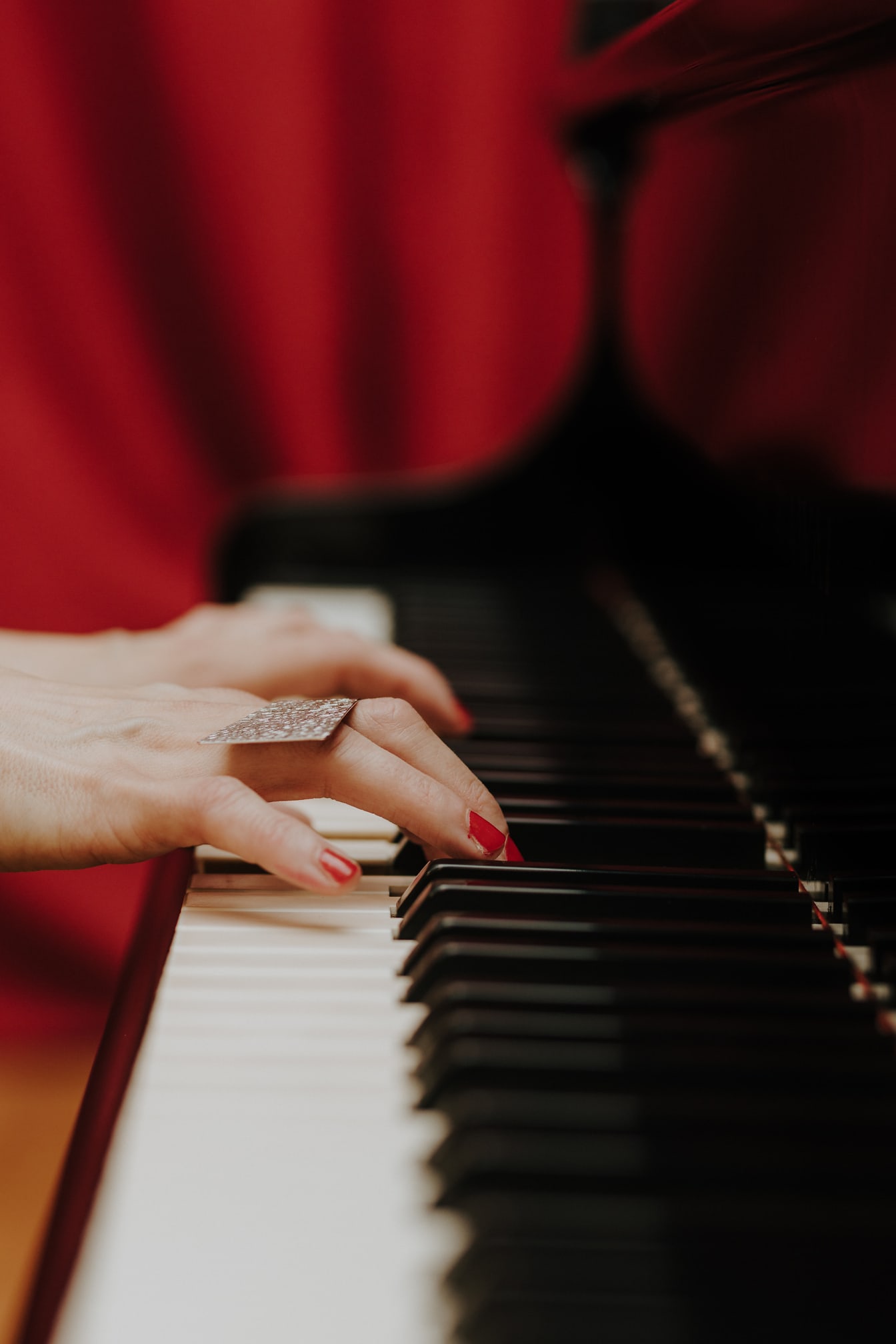 Detailný záber ruky hudobníka hrajúceho na klavíri