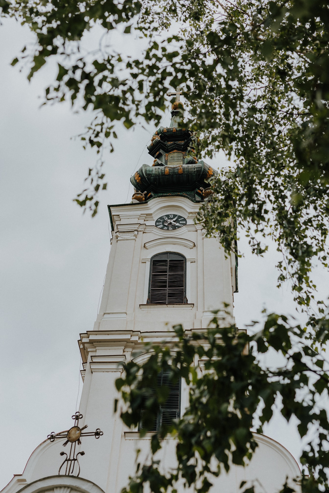 Mørkegrønn kirketårn av hvit ortodoks kirke i Serbia