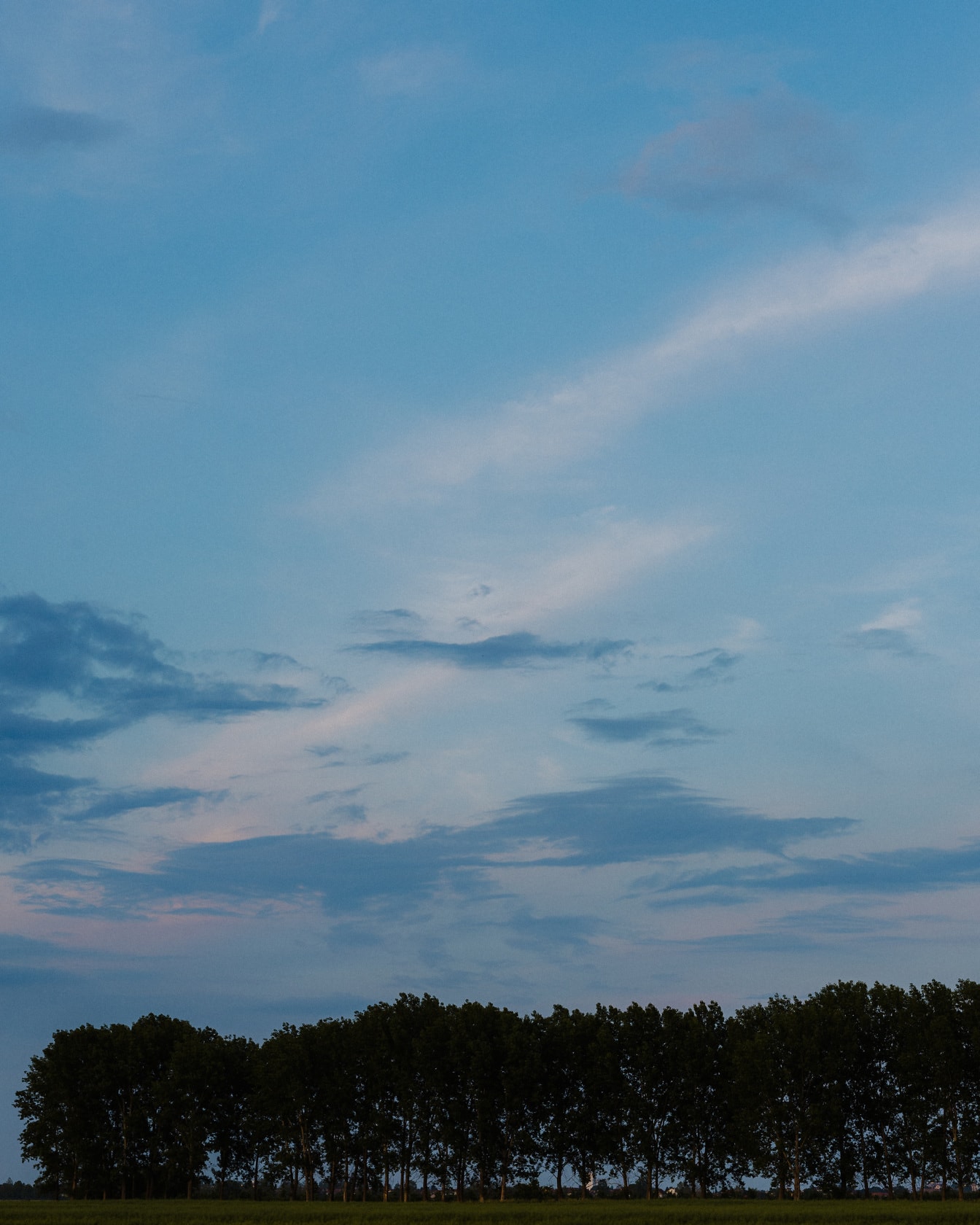 Блакитно-блакитне небо з хмарами над сільськогосподарським полем