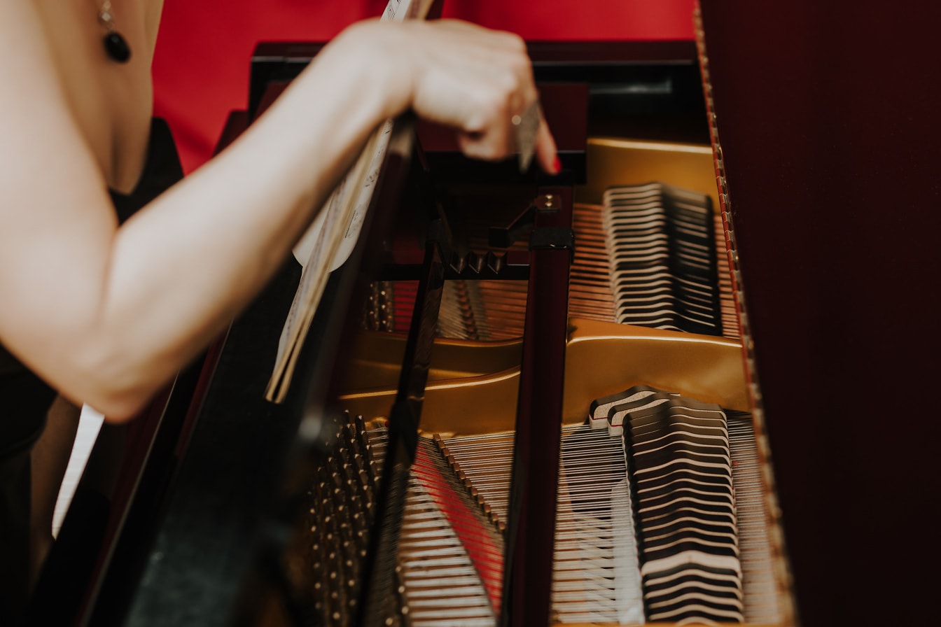 Close-up tangan musisi yang memainkan instrumen piano