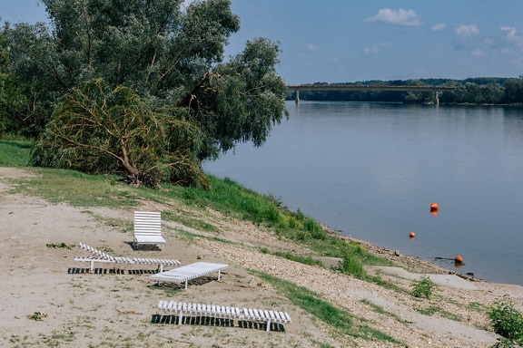 Riverbank of Danube river with white chairs