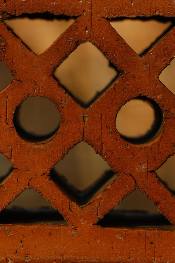 Close-up van donkerrode baksteen met gatentextuur