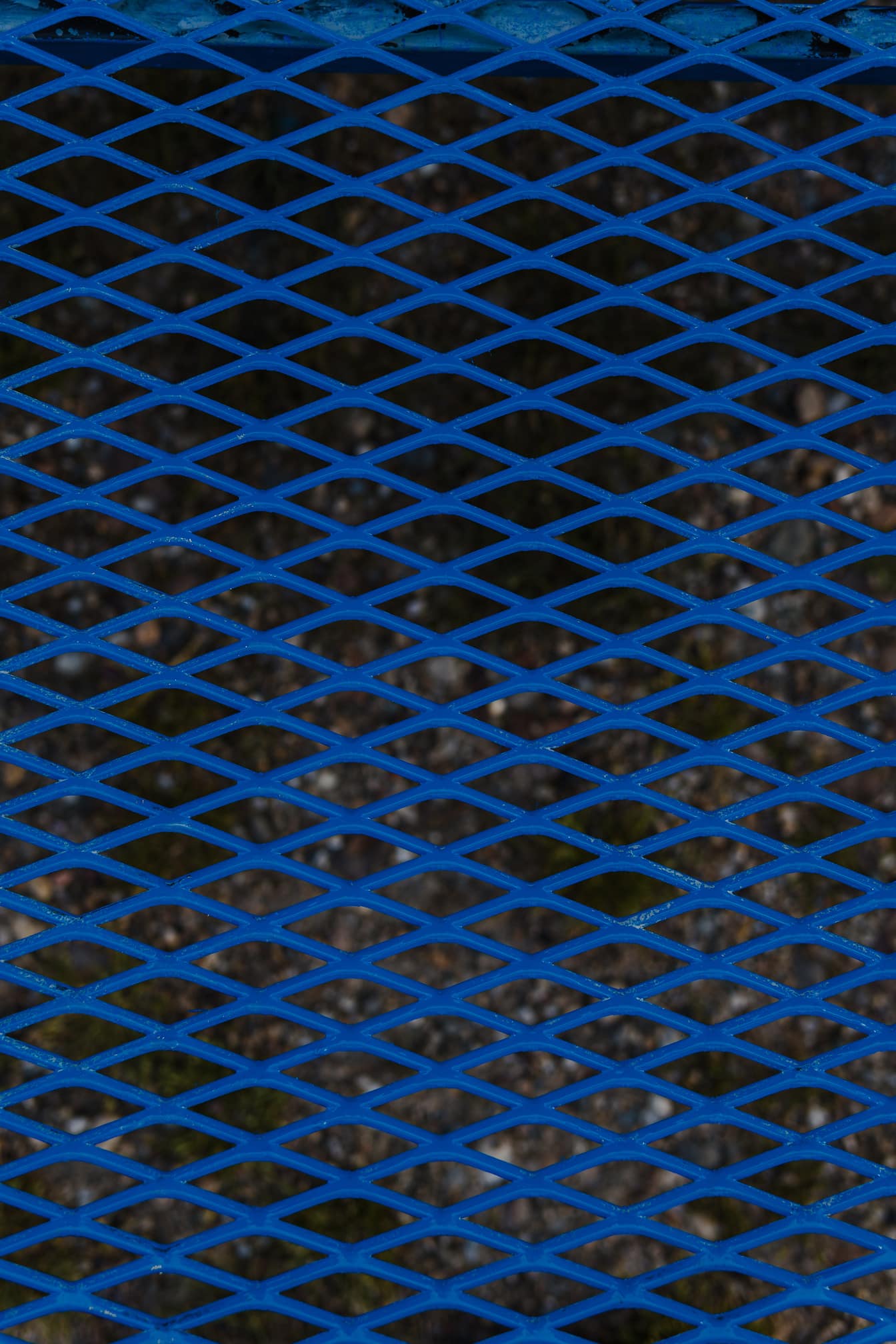 Tekstur kisi-kisi logam biru tua dengan pola geometris belah ketupat