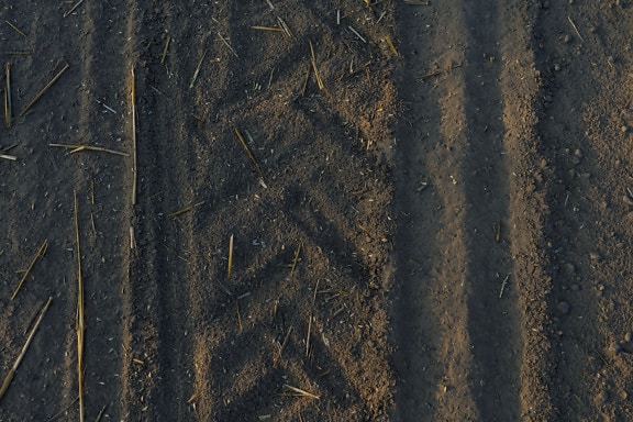 Texture of dry dark soil in agricultural field
