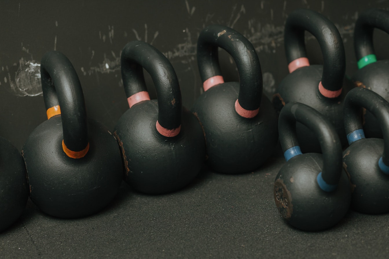 Black cast iron heavy dumbbells at gym floor