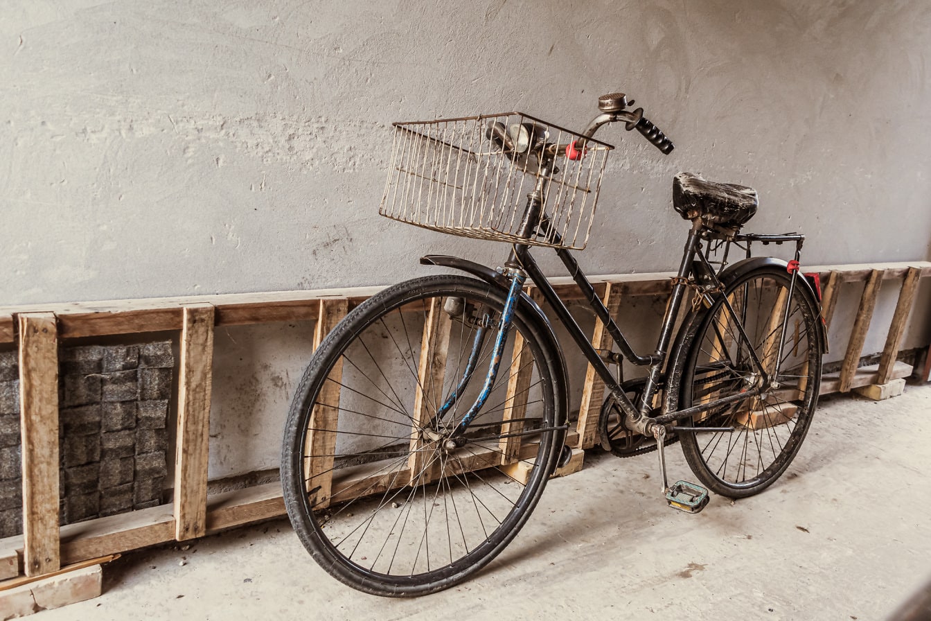 Starý štýl vintage čierny bicykel pri drevenom rebríku