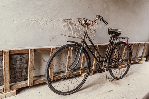 Old style vintage black bicycle by wooden ladder