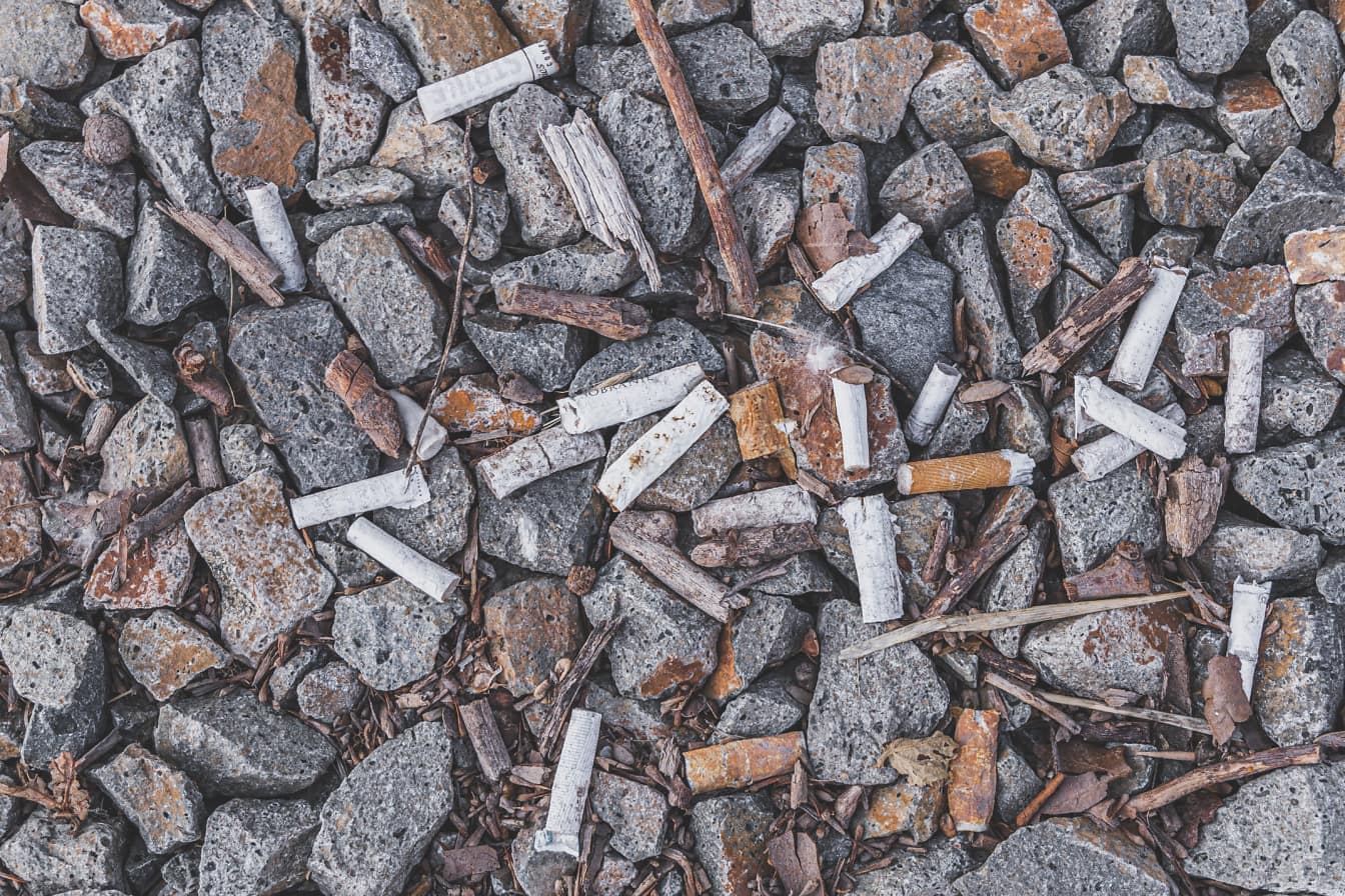Pontas de cigarro em close-up de pedras cinzentas