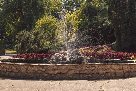 Fountain with round stone wall in botanical garden