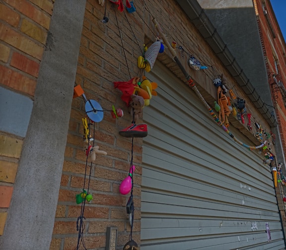 Many colorful toys hanging on wall by garage door