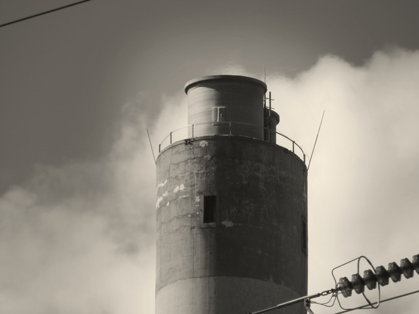 Industrielt vandtårn på elektrisk anlæg monokromt foto