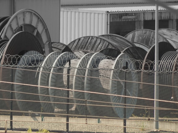 Sârmă ghimpată pe gardul instalației industriale din curte