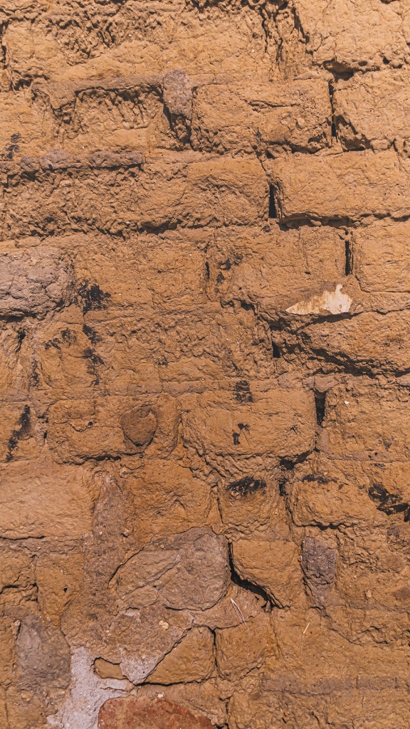 Yellowish brown adobe brick horizontal masonry close-up texture