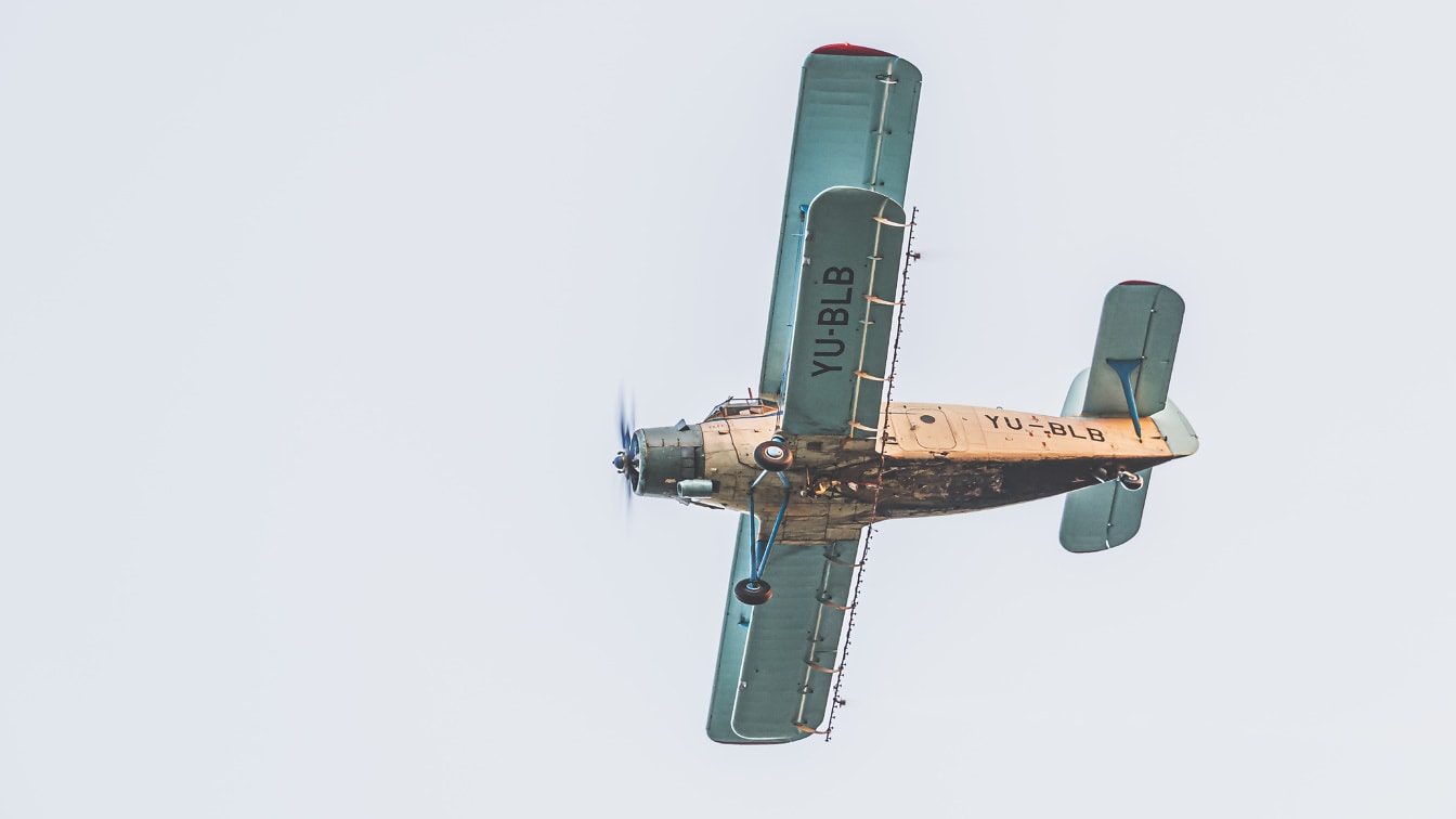 Doppeldecker-Flugzeug im alten Stil, das in Nahaufnahme von der Seite fliegt