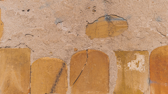 粗糙水泥墙纹理上的浅棕色陶土砖