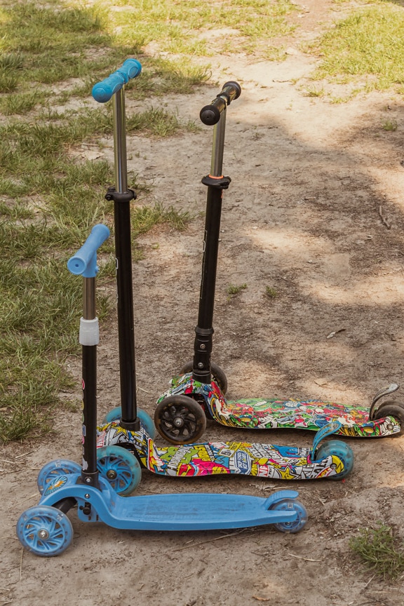Trois jouets de scooter colorés sur le sol en gros plan