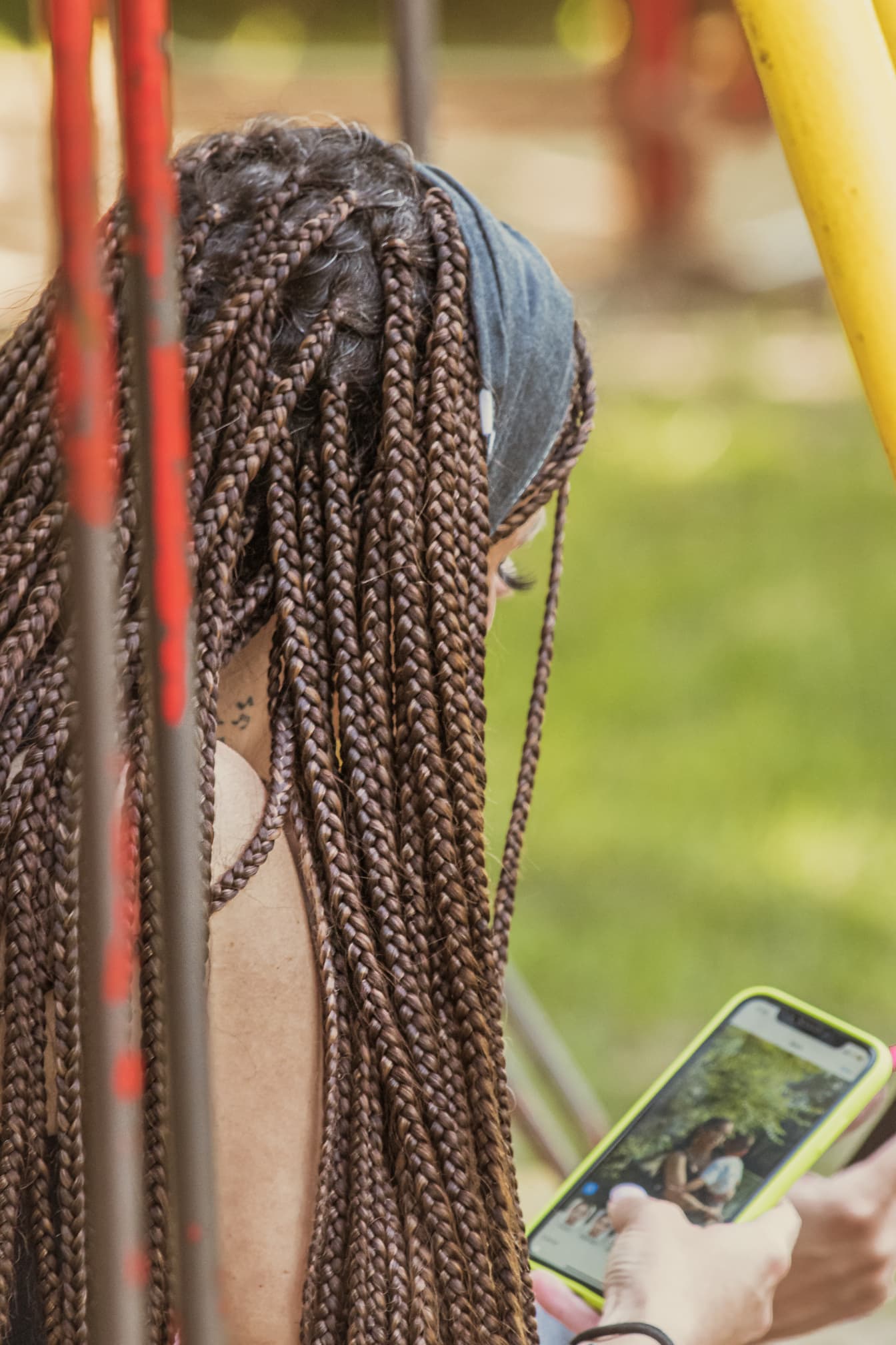 Yong brunetka kobieta z warkoczami fryzura trzymająca telefon komórkowy