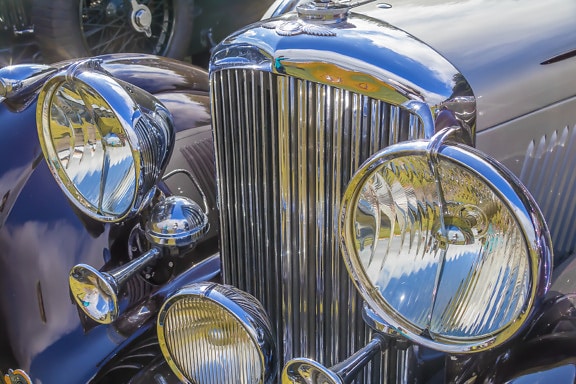 Bentley starožitná kapota klasického auta se zářícím kovovým světlometem