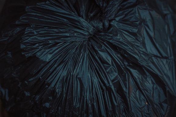 Close-up of black plastic garbage bag in shadow
