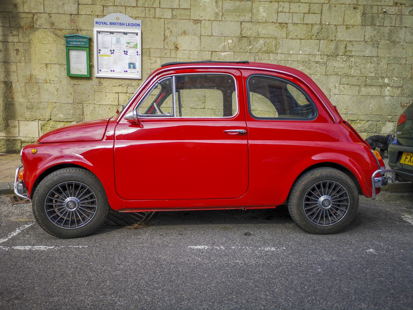 Fiat Nuova 500 mörkröd metallisk gammaldags bil på parkeringsplatsen