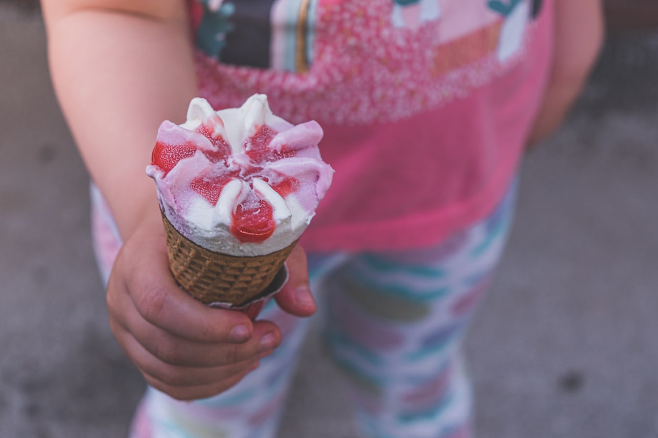 Detail ruky držící lahodný zmrzlinový kornout