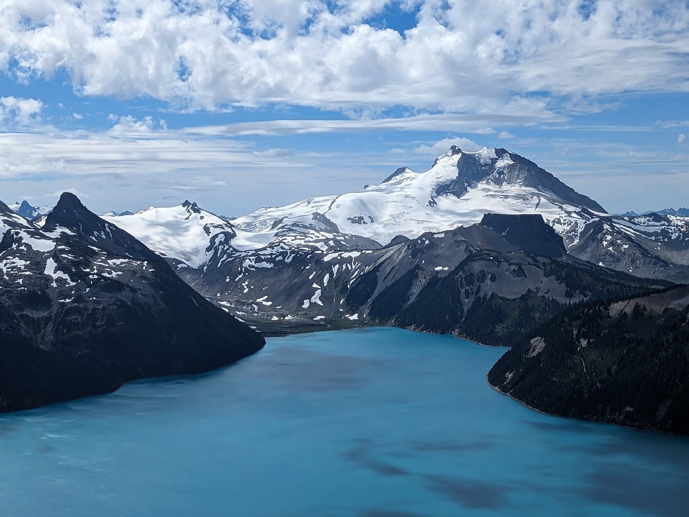 Arka planda karlı dağ zirveleri ile Garibaldi göl kenarı hava panoraması