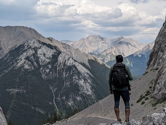 Pendaki backpacker di puncak gunung dan menyaksikan panorama lereng gunung
