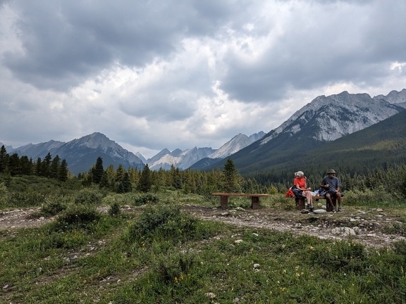 カナダ国立公園の山岳地帯でベンチに座るハイカーたち