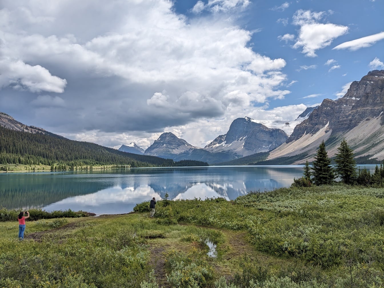 Turgåer fotograferer majestetisk panoramautsikt over innsjøen i nasjonalpark