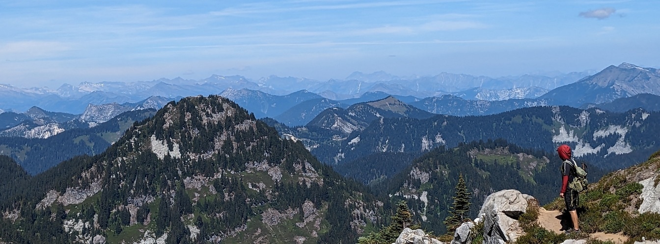 Turista s panoramatickým výhľadom z vrcholu hory
