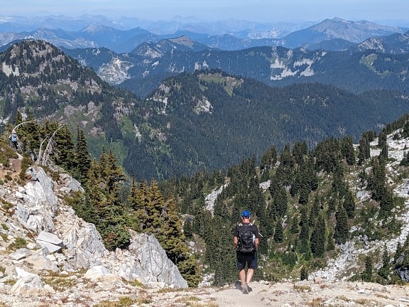 Backpacker mountain hiker walking downhill