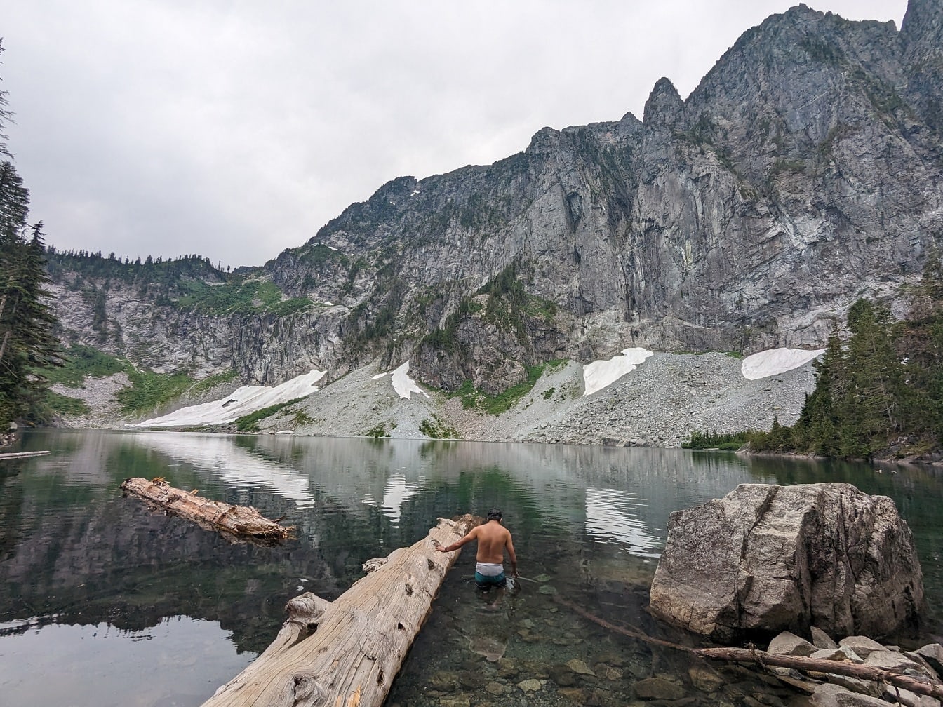 国立公園内の湖の冷たい水で水浴びをする男