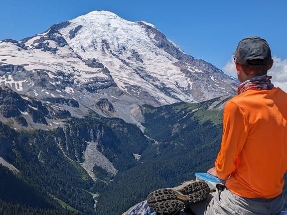homem, alpinista, montanha, sentado, desfrutando de, panorama, paisagem