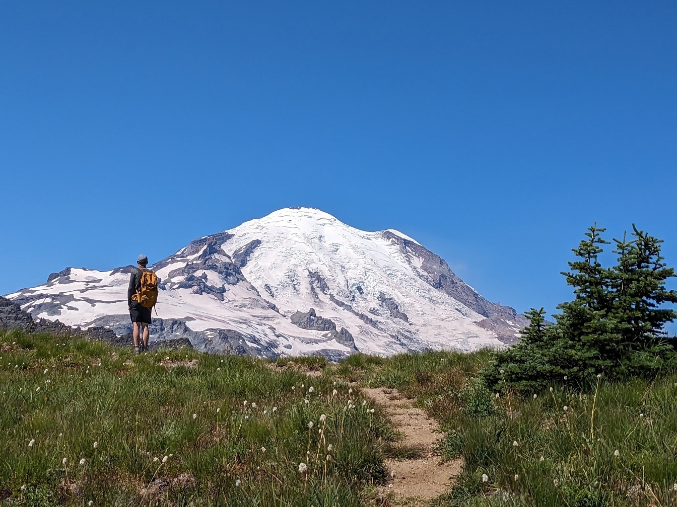 Альпініст стоїть і насолоджується панорамою на гірську вершину