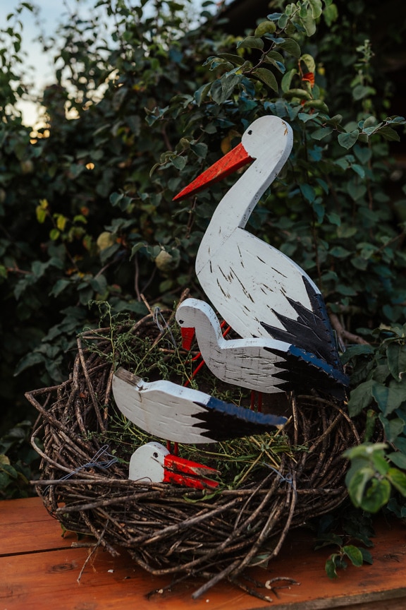 Wooden rustic decoration of white stork in nest