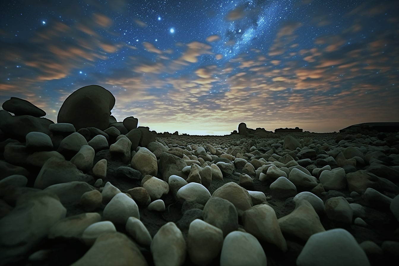 Nærbilde av store steiner på våt med mørkeblå nattehimmel