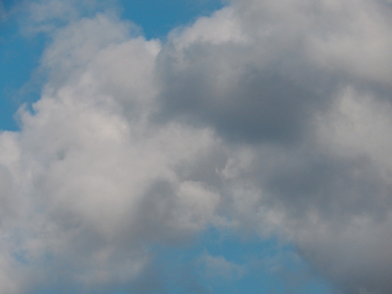 Сірі хмари на яскраво-синьому небі крупним планом