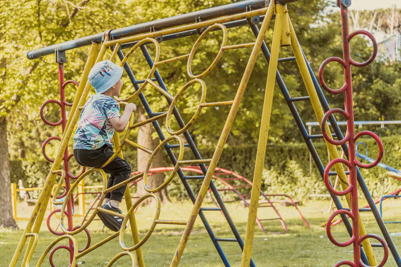 Drengebarn nyder sjov på legepladsen i forlystelsespark