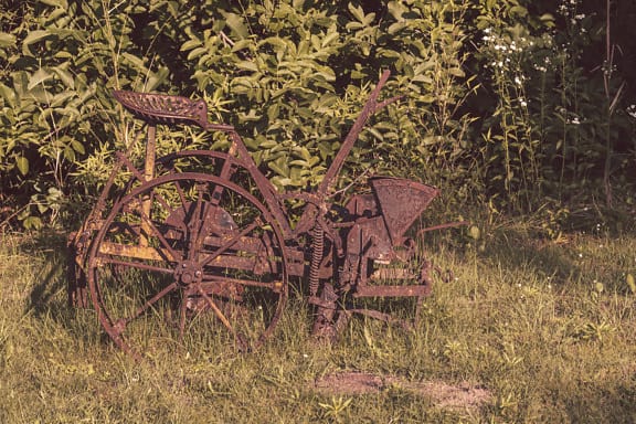 放棄された古い素朴な農業鋳鉄錆機