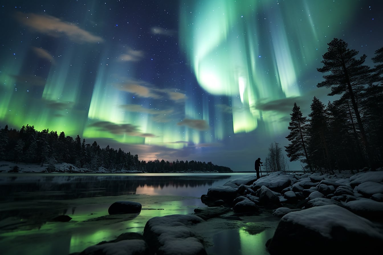 Aurora borealis night photography silhouette of person on riverbank