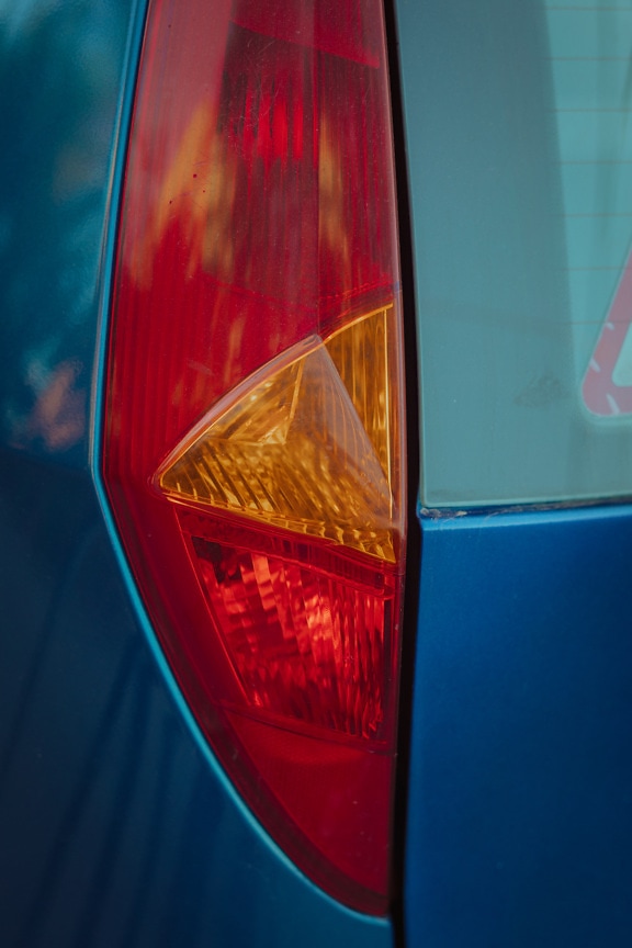 Nahaufnahme eines dunkelroten und orangegelben Kunststoffdetails eines Automobils